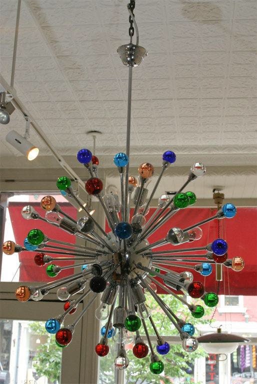 Spectacular supernova solid brass fixture. Dozens of rays with different color glass orbs, all dramatically Illuminated by 16 light bulbs.