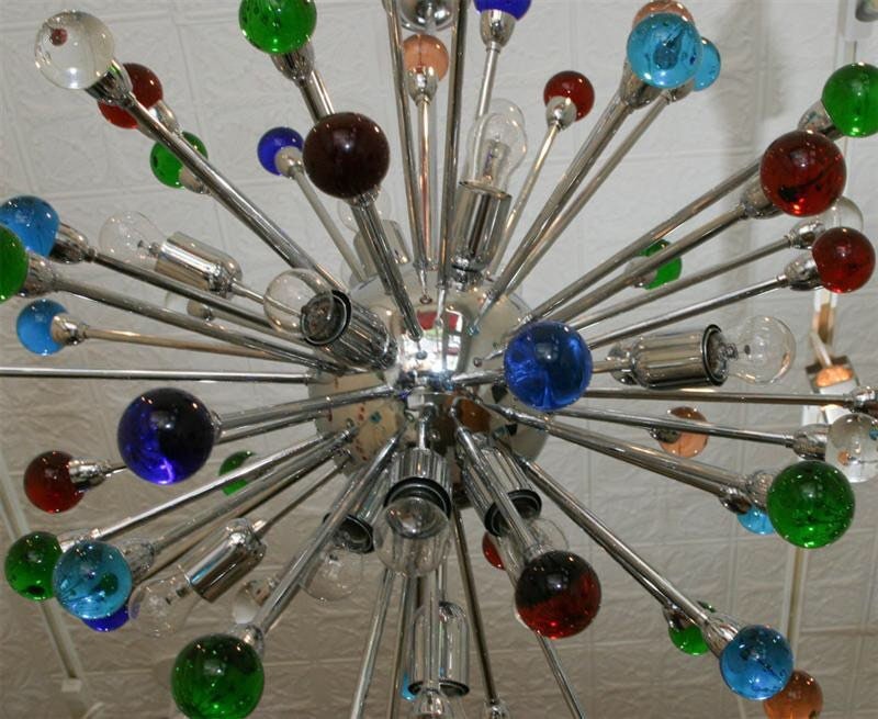 Spectacular supernova solid brass fixture. Dozens of rays with different color glass orbs, all dramatically Illuminated by 16 light bulbs.
