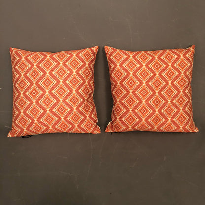Pair of new hand made modern pillows with geometric orange design.