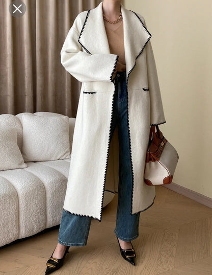 Double breasted hand sew coat in cream with black trim contrast color